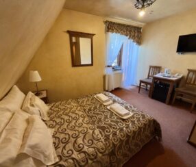 Pokój dwuosobowy z balkonem i łóżkiem małżeńskim