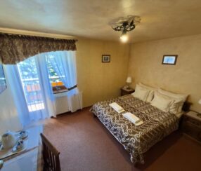 Pokój dwuosobowy z balkonem i łóżkiem małżeńskim