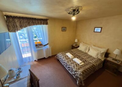 Pokój dwuosobowy z balkonem i łóżkiem małżeńskim